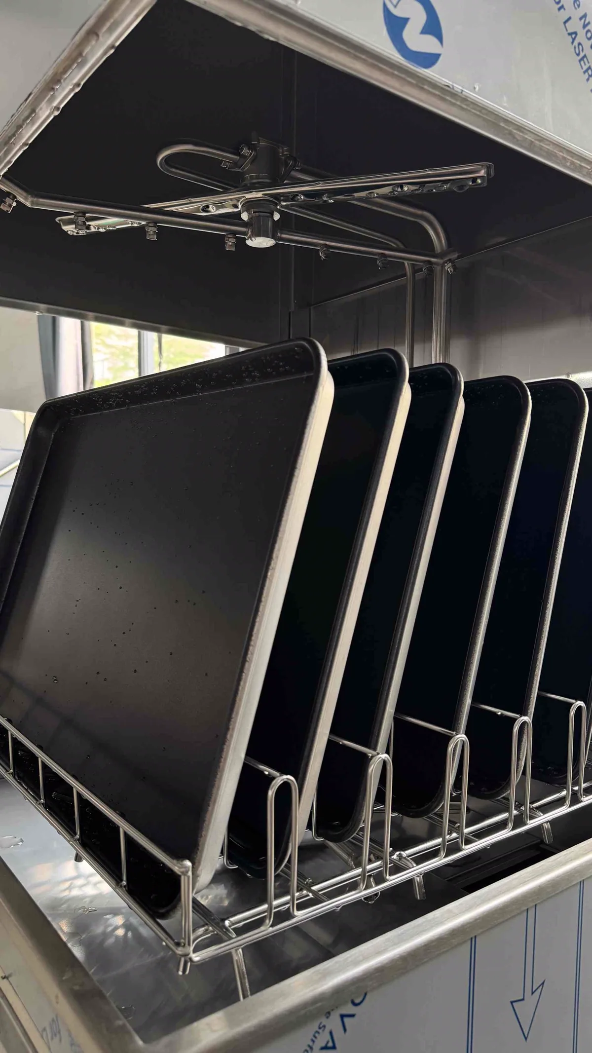 Six 600×400 mm baking trays loaded upright in the JD-3 wash rack